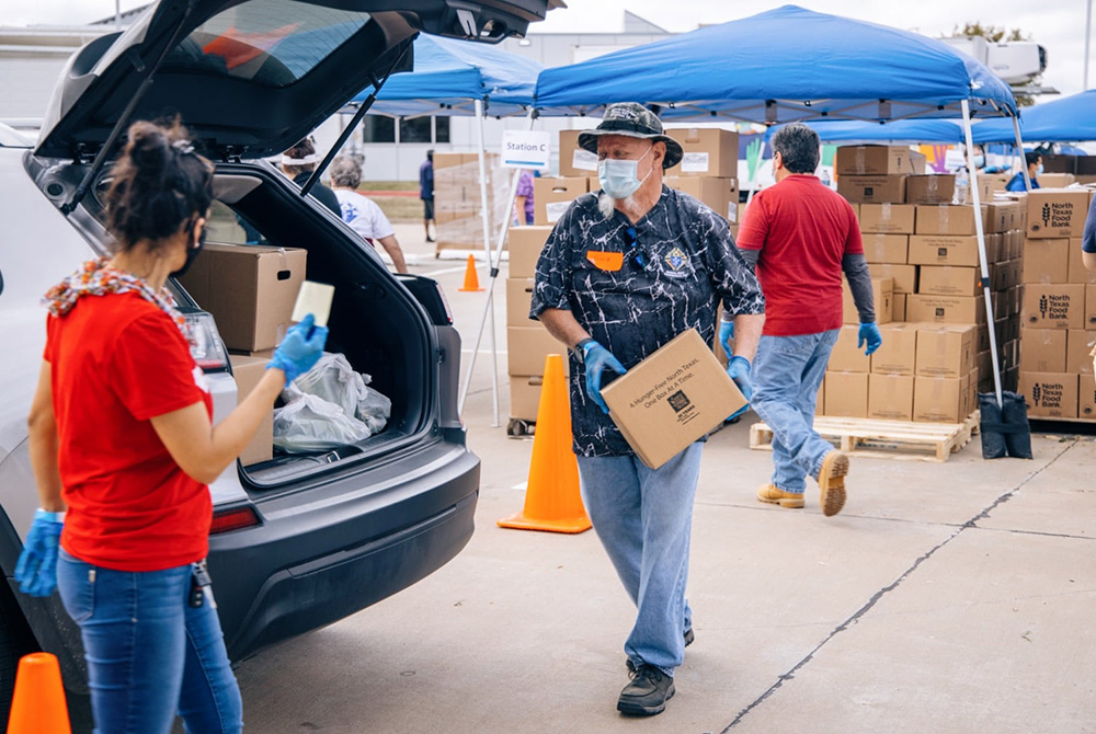 Staff with Catholic Charities Dallas load boxes of food into cars of families at a distribution center in July 2020. (Courtesy of Catholic Charities Dallas) Staff with Catholic Charities Dallas load boxes of food into cars of families at a distribution center in July 2020. (Courtesy of Catholic Charities Dallas)