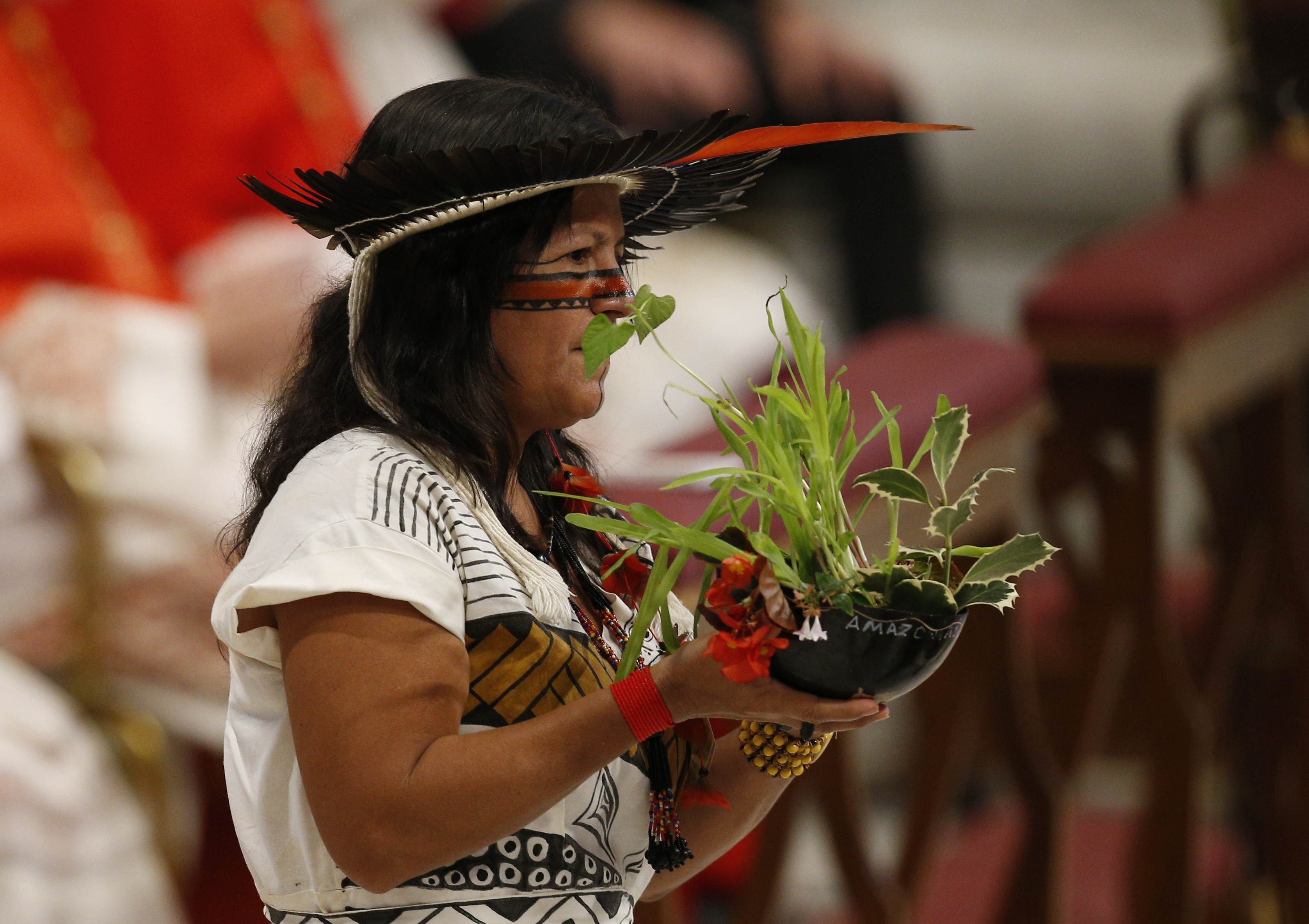 Marcivana Rodrigues Paiva, representing the Satere-Mawe indigenous people in Brazil, carries a plant in the offertory procession as Pope Francis celebrates the concluding Mass of the Synod of Bishops for the Amazon at the Vatican Oct. 27, 2019. (CNS photo