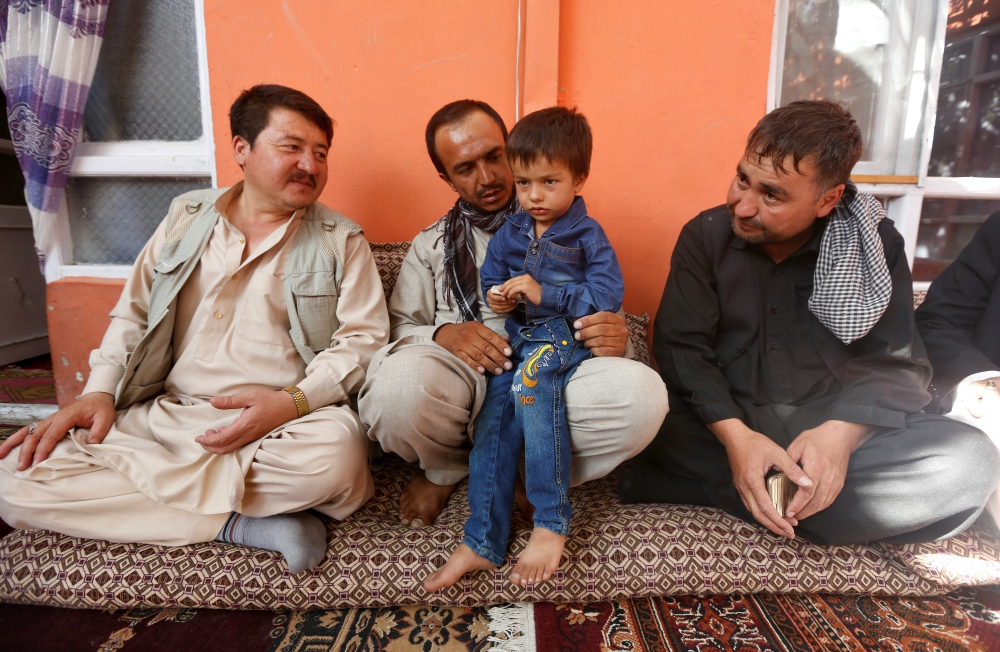 Ali Ahmad, 4, sits with his father and relatives at their house after he survived a suicide attack at a mosque in Kabul, Afghanistan, Aug. 27. (Newscom/Reuters/Omar Sobhani)