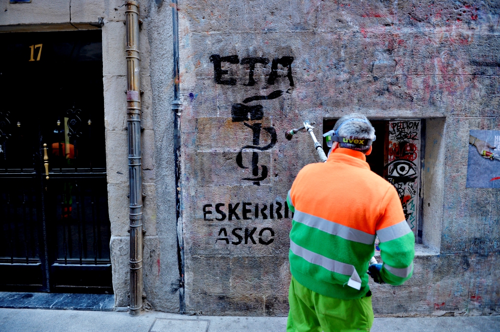 A municipal worker in Bilbao, Spain, on May 5 removes graffiti reading, "ETA, thanks," two days after the militant Basque separatist group ETA announced it had completely disbanded. (Newscom/Reuters/Vincent West)