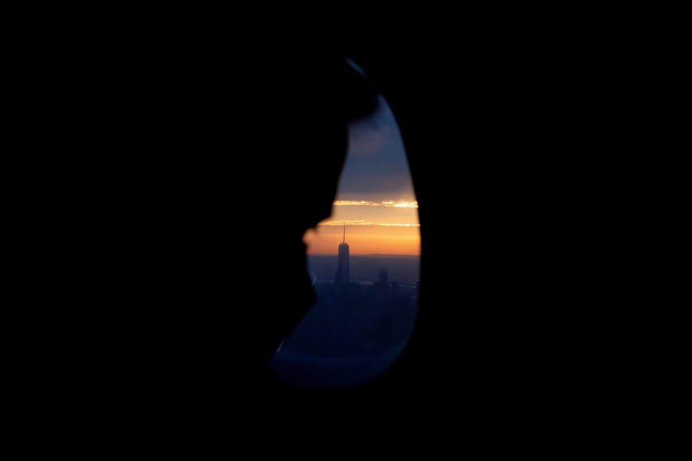 A man on an airplane looks at the One World Trade Center in New York City Sept. 9, 2021. 