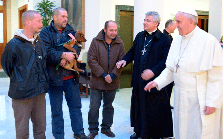 Pope Francis talks with three men Dec. 17 who live on the streets near the Vatican. On his 77th birthday, the pope celebrated morning Mass and had breakfast with the men. (CNS/Reuters/L'Osservatore Romano)
