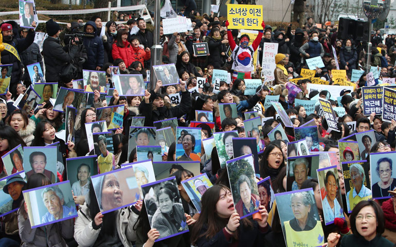 South Korean protesters hold up pictures of deceased former "comfort women" during a rally near the Japanese Embassy in Seoul, South Korea, Dec. 30. (Newscom/EPA/Ang Ji-woong)
