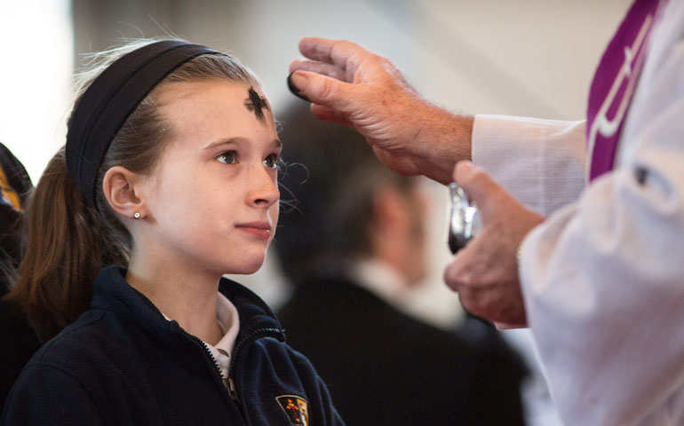 Deacon Gerald Geiser of St. Raphael the Archangel Catholic Church in St. Louis, distributes ashes to fourth-grader Mia Thompson during a Feb. 18, 2015, Ash Wednesday Mass with the schoolchildren at the parish. (CNS/St. Louis Review/Lisa Johnston)