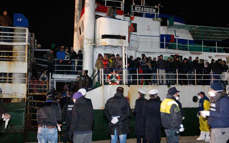 Migrants stand on the deck of the Ezadeen as they arrive at Corigliano Calabro harbor in Southern Italy early Jan. 3. (Newscom/Reuters/Antonino Condorelli)