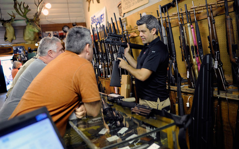 Store owner Brooke Misantone shows his last two AR-15 semi-automatic rifles to customers at the Bullet Hole gun shop in Sarasota, Fla., Jan. 16. (Newscom/Reuters/Brian Blanco)