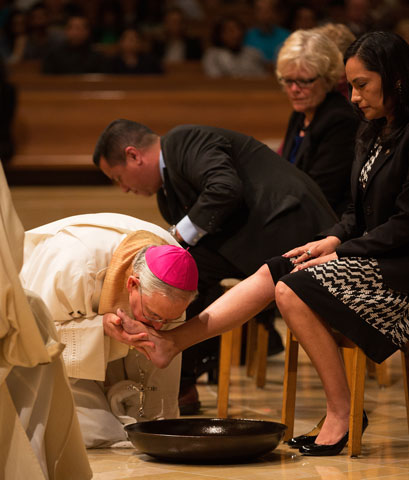 Los Angeles Archbishop José Gomez kisses the foot of a woman during Holy Thursday Mass in 2014 at the Cathedral of Our Lady of the Angels in Los Angeles. (CNS/Vida Nueva/Victor Aleman)