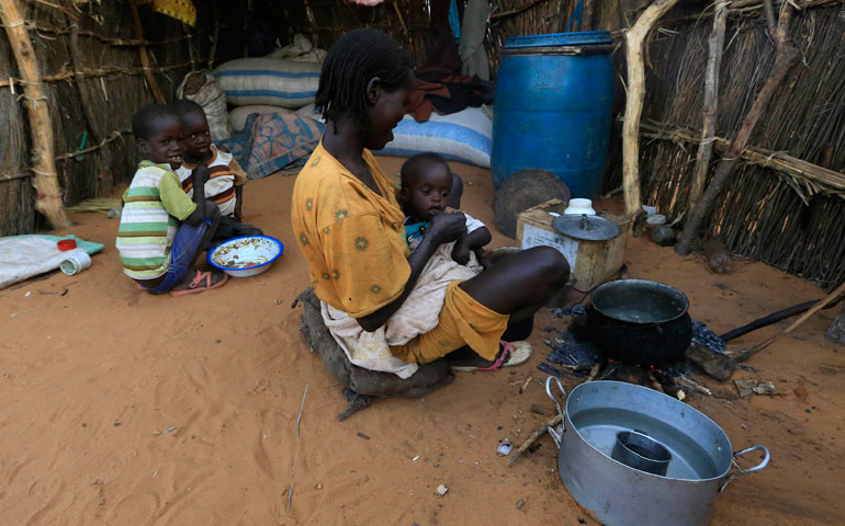 An internally displaced woman feeds her child near an African Union/United Nations Mission in Darfur base near Labado, Sudan, Dec. 9. (Reuters/Mohamed Nureldin Abdallah)