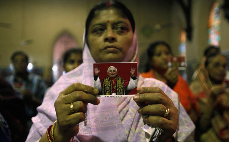 A woman holds a portrait of Pope Benedict XVI during a Mass in his honor in Kolkata, India, Feb. 26. (CNS/Reuters/Rupak De Chowdhuri)