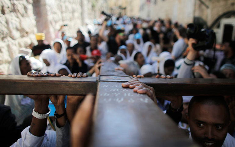 Christians carry a cross during a procession along Via Dolorosa in Jerusalem's Old City on Good Friday in 2014. (CNS/Reuters/Ammar Awad)