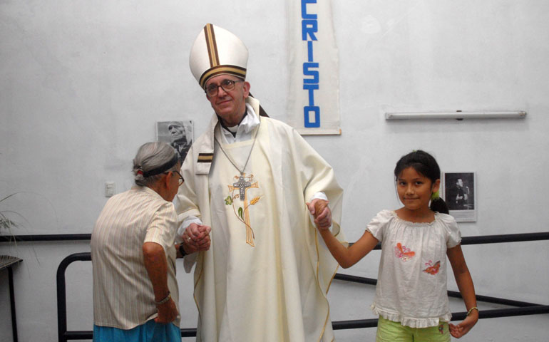 Argentine Cardinal Jorge Mario Bergoglio holds the hands of a woman and girl during Holy Thursday Mass in 2008 at a church in a poor section of Buenos Aires, Argentina. (CNS/Reuters/Enrique Garcia Medina)