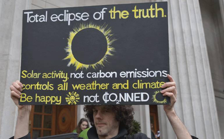 A man protests outside the "This Changes Everything" conference on climate change March 28 in London. (Newscom/Zuma Press/Jonathan Nicholson)