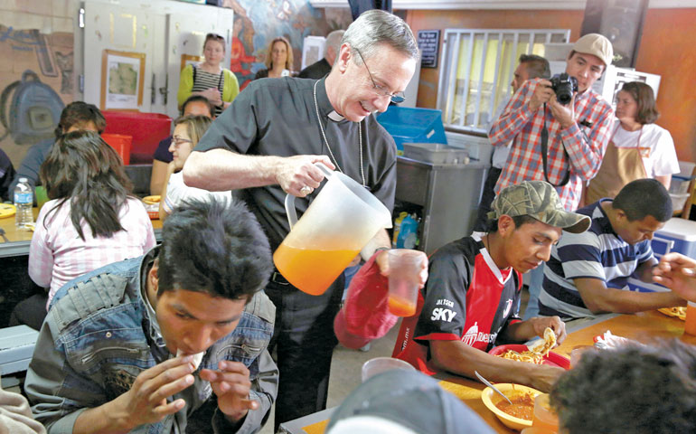 Auxiliary Bishop Luis Zarama of Atlanta serves juice to men at the Aid Center for Deported Migrants in Nogales, Mexico, March 31. Dinner that evening was served by visiting U.S. bishops. (CNS/Nancy Wiechec)
