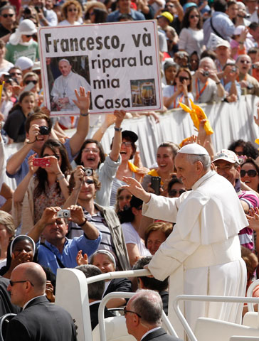 Pope Francis greets the crowd as he arrives to lead his general audience in St. Peter’s Square at the Vatican May 1. The sign in the crowd in Italian says “Francesco, go rebuild my house,” a reference to Jesus’ words to St. Francis in an apparition. (CNS/Paul Haring)