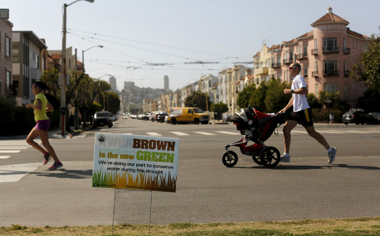 Runners jog past a sign on the Marina Green in San Francisco April 23. California is entering the fourth year of a devastating drought. (Newscom/Reuters/Robert Galbraith)