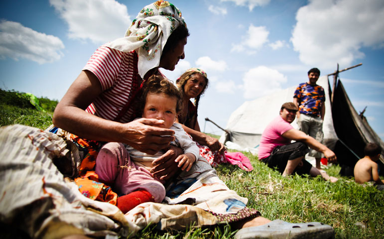 A Roma family in a Gypsy camp rests in Valea Stanii, Romania, in May 2012. (CNS/EPA/Mihai Barbu)