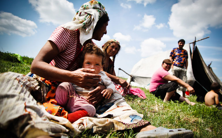 A Roma family in a Gypsy camp rests in Valea Stanii, Romania, in May 2012. (CNS/EPA/Mihai Barbu)