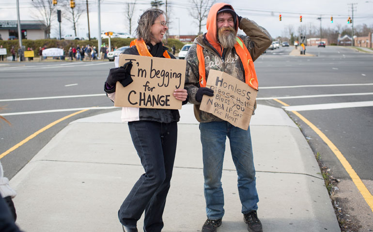 Beth Brockman, left, as part of a large group of ministers and supporters, joins panhandler Carl Bittner, right, in March 2013 to protest a new ordinance outlawing panhandling on "busy streets" in Durham, N.C. (D.L. Anderson)