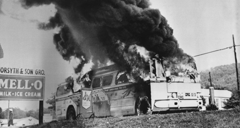 A Freedom Rider bus goes up in flames near Anniston, Ala., May 14, 1961, after a firebomb was tossed through a window. Passengers escaped without serious injury. (AP Photo)