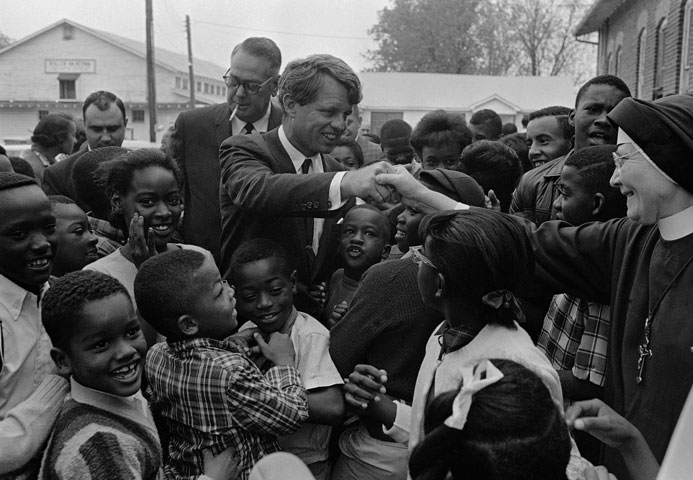 Sen. Robert Kennedy shakes the hand of a Catholic nun as he is surrounded by elementary students in a visit to an anti-poverty program in Greenville, Miss., in April 1967. (AP Photo)