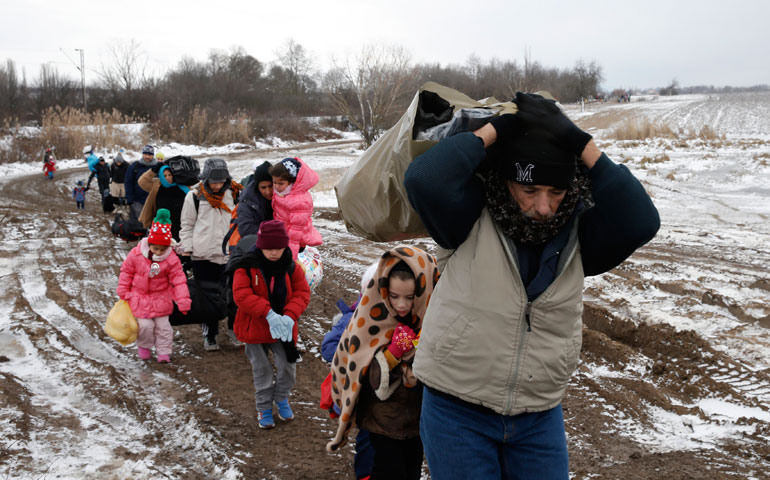 Migrants walk through a frozen field after crossing the border from Macedonia, near the village of Miratovac, Serbia, Jan. 18. (CNS/Reuters/Marko Djurica)