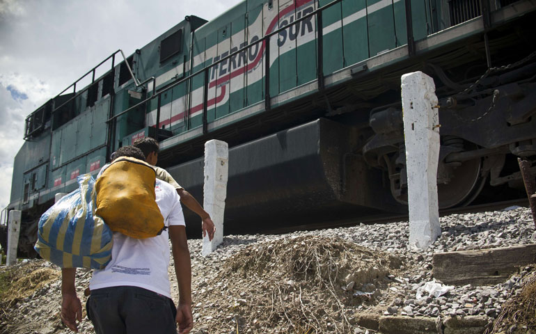 In Mexico July 22, a Central American migrant walks toward “La Bestia,” a cargo train headed for the U.S. border. (Newscom/AFP/Getty Images/Ronaldo Schemidt)