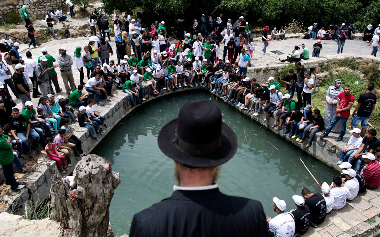 An ultra-Orthodox Jew watches Palestinians protest in the old abandoned Arab village of Lifta, near Jerusalem, May 16 to mark Nakba Day. Lifta’s villagers fled during the 1948 War of Israeli Independence. (EPA/Abir Sultan)