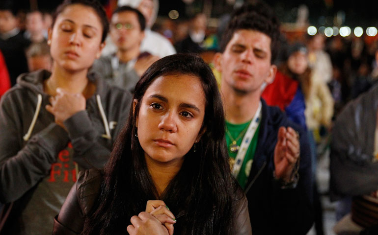 Young people pray during the Eucharist adoration led by Pope Francis at the World Youth Day vigil on Copacabana beach in Rio de Janeiro July 27. (CNS/Paul Haring)