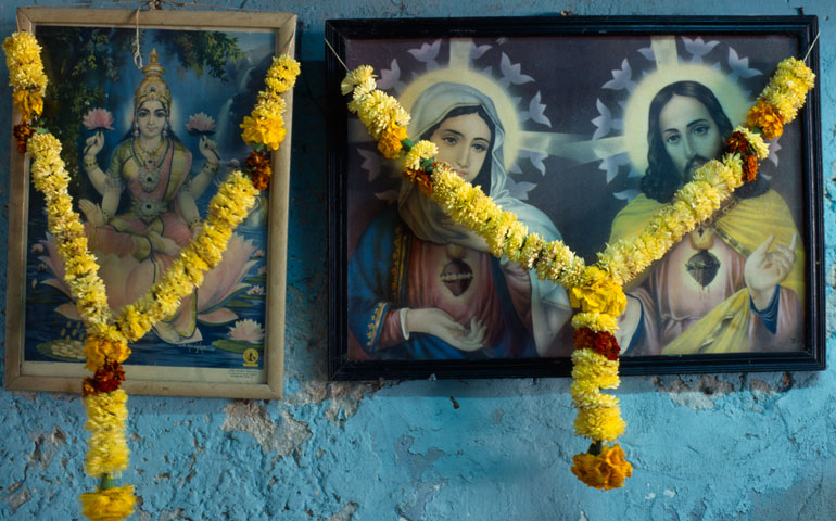 Framed pictures of Hindu and Christian iconography hung with marigold flower garlands are seen in India. (Newscom/Eye Ubiquitous)