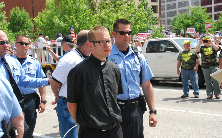 Police arrest Fr. Andy Switzer among others who sat in the street in protest at a May 21 miners’ rally in St. Louis. (Courtesy of UMWA/David Kameras)