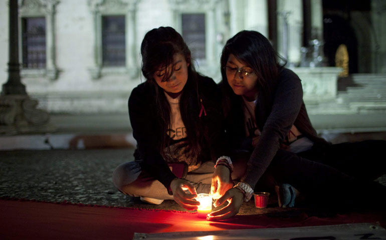 Two women take part in an event for World AIDS Day in Guatemala City Dec. 1, 2012. (Newscom/EFE/Saul Martinez)