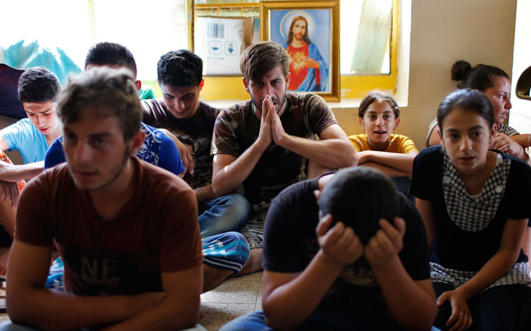Displaced Iraqi Christians who fled from Islamic State militants in Mosul pray at a school acting as a refugee camp in Irbil, Iraq, Sept. 6. (CNS/Reuters/Ahmed Jadallah)