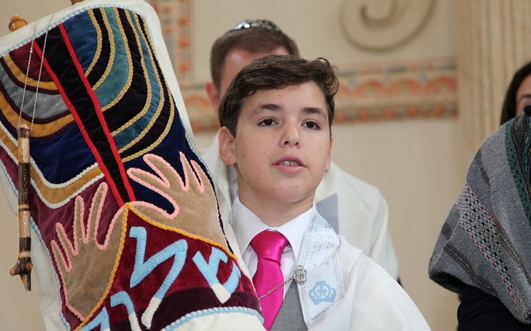 Jacob Wisnik holds the covered Torah during his bar mitzvah in the Zamosc Synagogue in Poland July 3. (Photos by Krzysztof Galica)