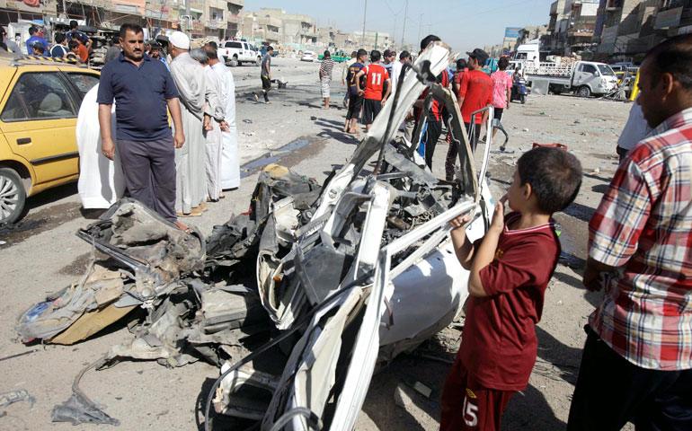 Iraqis inspect the site of a car bomb attack in northern Baghdad July 29. (Newscom/EPA/Ahmed Ali)