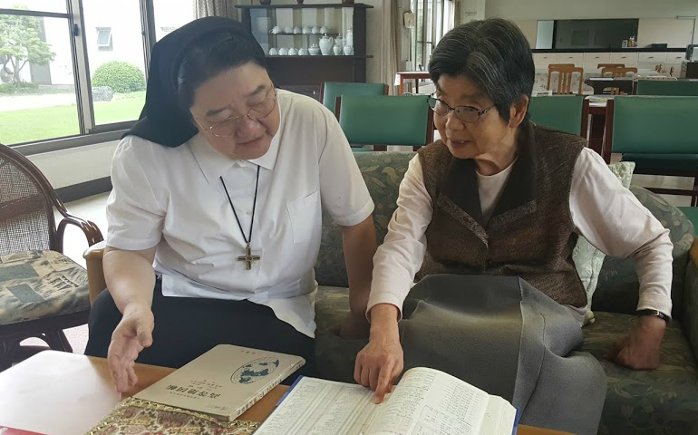 Sr. Masako Miyake, left, talks to Sr. Estelle Kazuko Takabayashi, who was sharing her memory book. (GSR photo / Gail DeGeorge)