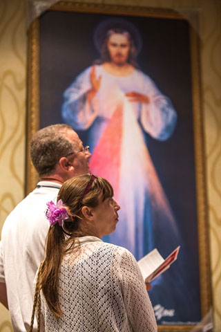 Patrick and Cindy Rice from Oregon review Divine Mercy images and materials of the Apostles of the Divine Mercy apostolate Aug. 4 in Orlando, Fla. (CNS/Tom Tracy)