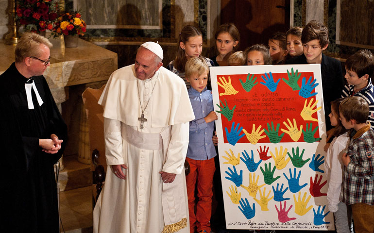 Pope Francis receives a gift from children during a visit to Christuskirche, a parish of the German Evangelical Lutheran church, in Rome on Nov. 15, 2015. (CNS/Catholic Press/ Massimiliano Migliorato)