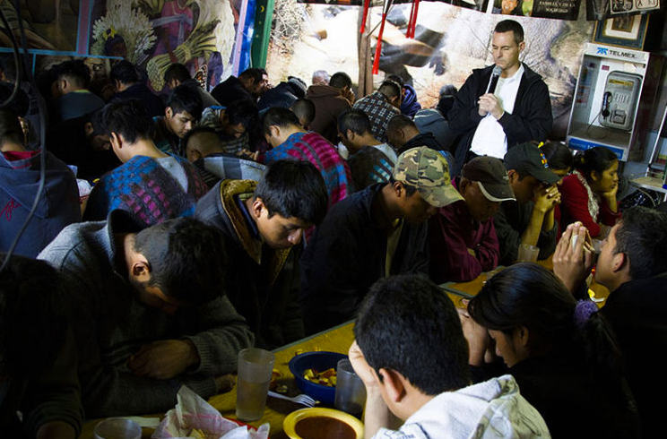 Jesuit Father Sean Carroll leading a prayer at el Comedor — at Comedor KBI Nogales