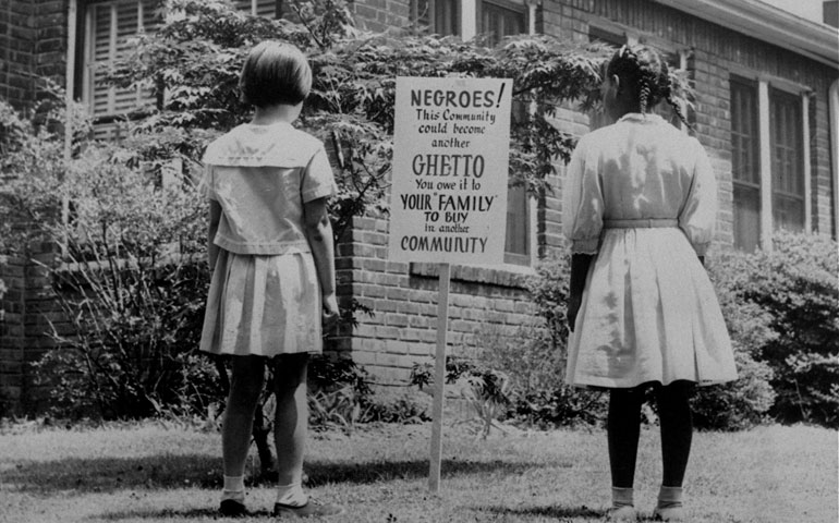 Two girls study a sign in Lakeview, N.Y., in April 1962. The sign was an attempt to keep African-Americans from exceeding the number of whites living in the integrated town. (AP Photo)