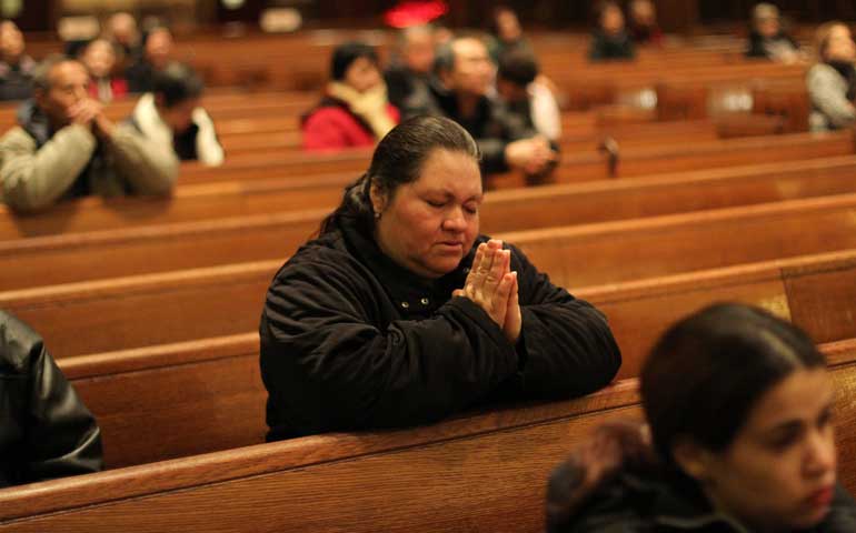 A woman prays during a bilingual Mass of Thanksgiving for the election of Pope Francis at St. Joan of Arc Church in New York in March 2013. (CNS/Gregory A. Shemitz)