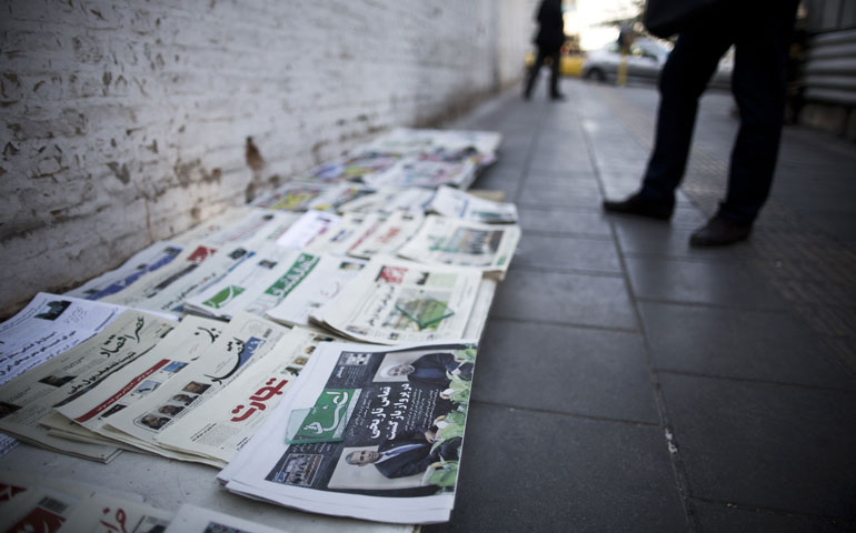 An Iranian looks at newspapers with pictures of Iranian President Hassan Rouhani and U.S. President Barack Obama on a newsstand in Tehran Sept. 28. (Newscom/Getty Images /AFP/Behrouz Mehri)