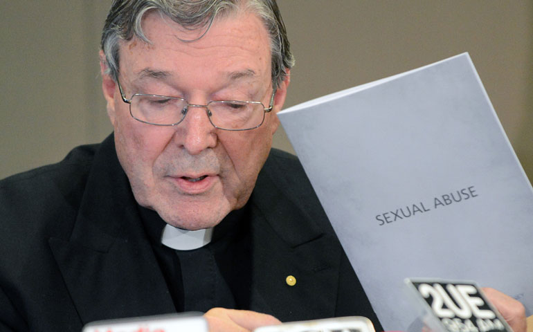 Cardinal George Pell of Sydney holds a copy of church protocols for dealing with sexual abuse during a Nov. 13 news conference responding to the Australian government’s establishment of a royal commission into child sexual abuse. (Newscom/Getty Images/AFP/Roslan Rahman)