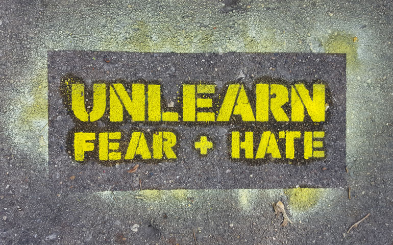 The stenciled words “Unlearn Fear + Hate” are part of an international community art project. (Courtesy of Aaron Doolittle and Jordan Hampton)