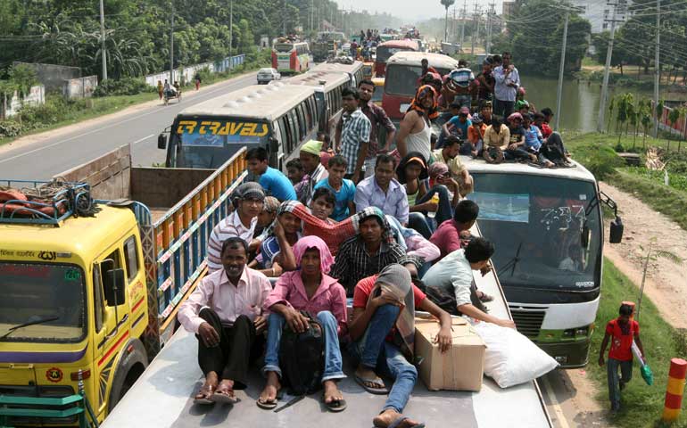 Bangladeshi people sit atop a bus in Dhaka Oct. 3, prior to traveling across the country to celebrate Eid al-Adha. At least 3 million people leave the capital city to join their relatives in their home villages for the festival. (Newscom/Sipa USA/Palash Khan)