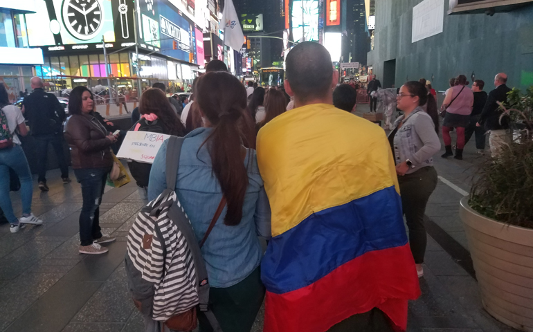 Some of those celebrating the Colombian peace agreement in Times Square draped the Colombian flag in celebration. (GSR/Chris Herlinger)