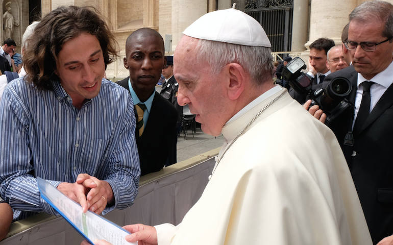Global Catholic Climate Movement representatives Tomás Insua, left, and Allen Ottaro, center, present Pope Francis with a copy of a petition calling for world leaders to address climate change during the pope's weekly audience in St. Peter's Square May 6. (Fotografia Felici)