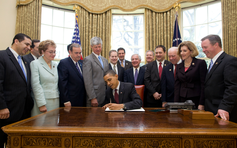 Some Democratic members of the House of Representatives stand by President Barack Obama as he signs an executive order March 24, 2010, to ensure that no federal funds are spent on abortion under the new health reform plan. (CNS photo/Pete Souza, White House)