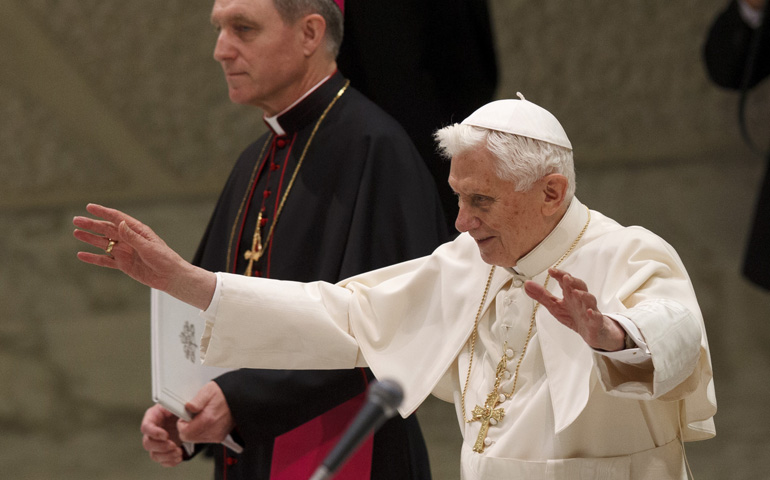 Pope Benedict XVI greets pilgrims as he begins his Feb. 6 general audience in Paul VI hall at the Vatican. Also pictured is Archbishop Georg Ganswein, prefect of the papal household and the pope's personal secretary. (CNS/Paul Haring)