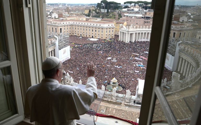 Pope Francis waves to the crowd from the window of his private apartment as he leads his first Angelus in St. Peter's Square at the Vatican March 17, 2013. (CNS/L'Osservatore Romano) 