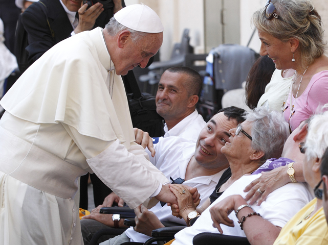Pope Francis greets people in wheelchairs after celebrating Mass June 16 in St. Peter's Square at the Vatican. (CNS/Paul Haring)